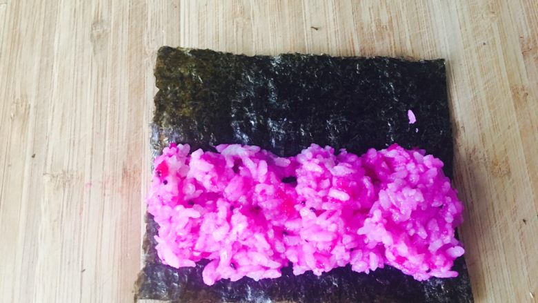 童趣寿司,取1／2紫菜。这时的紫菜宽度，也是和山药宽度同宽。把饭团包起来。