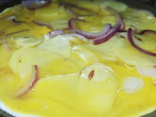 西班牙土豆烘蛋饼,倒入蛋液，左右晃动锅子，使蛋液分布均匀。盖锅盖小火慢煎5到10分钟。（看各自情况）