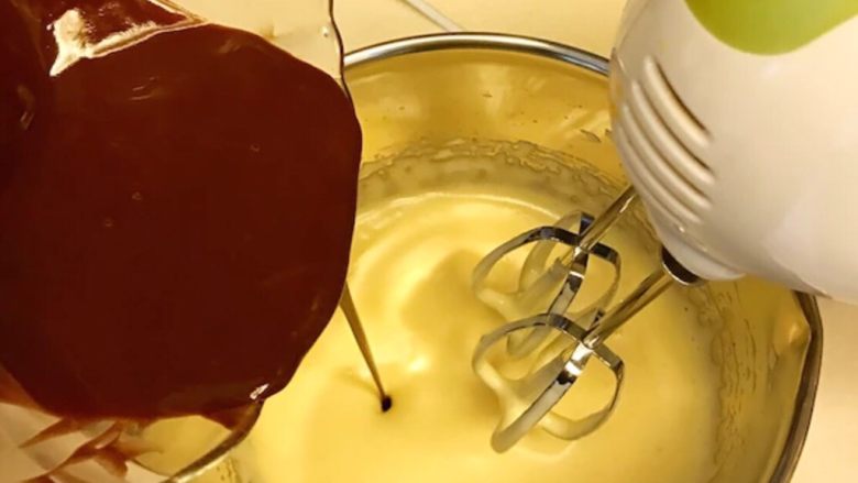 治愈系《Oreo布朗尼》【蛋糕篇】,融化好的巧克力黄油液体，倒入鸡蛋液中，电动打蛋器高速打匀。（一边倒入，一边打匀），让两种液体充分的混合在一起。