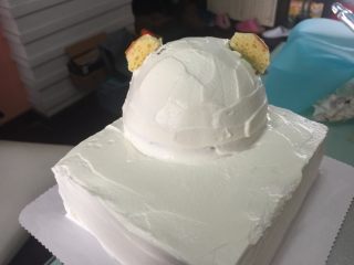 立体小熊蛋糕,用剩下的蛋糕片剪裁出耳朵形状，用刚才裱花的豆沙奶油霜固定，放人冰箱冷藏一会