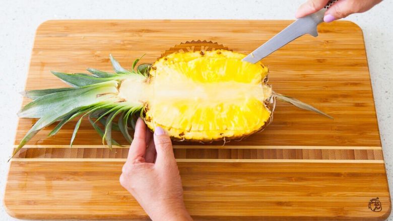 热带风菠萝炒饭,使用刀沿菠萝边缘切割，距离边缘约1/4，要小心不要穿过菠萝的底部
