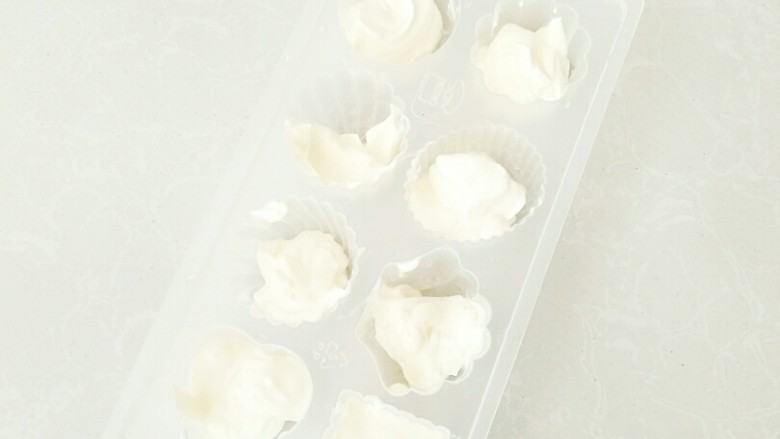西瓜奶油冰棒,用勺子把奶油均匀的放入模具中。