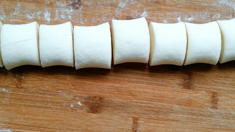 超萌豆沙熊宝贝,发酵好的面团排气，重新揉至光滑切开无气孔状态。平均分成两块，取其中一块搓长，平均分成八份