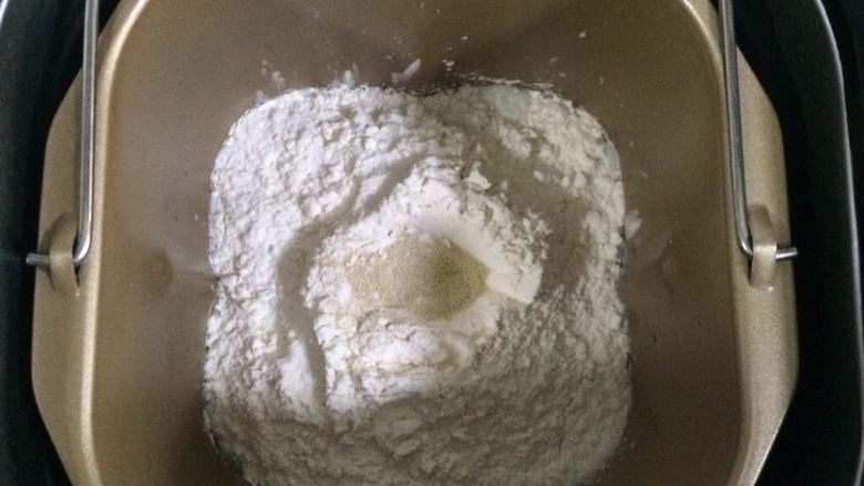 葡萄干椰蓉泡浆面包,除<a style='color:red;display:inline-block;' href='/shicai/ 887'>黄油</a>以外的面包材料都放入面包机内（先液体后粉类的顺序），在面粉中间挖个洞，把酵母粉倒进去，启动和面程序。
