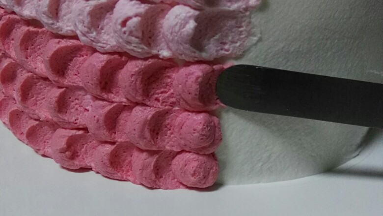 渐变奶油蛋糕,圆形奶油用抹刀轻轻压着往后拉一下（如图）抹完再竖着挤一层奶油。