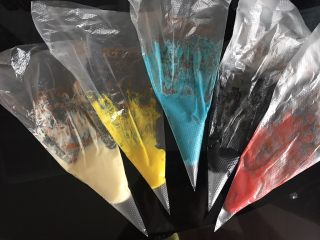 哆啦A梦彩绘蛋糕卷,面糊按照颜色多少分成五份调色，黑色描边部分用竹炭粉调色，白色部分用原色，其余用色素调色，装入裱花袋。