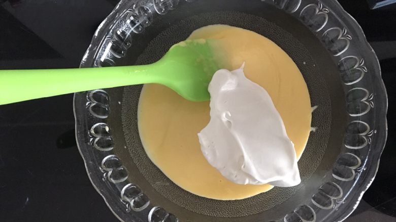 哆啦A梦彩绘蛋糕卷,将三分之一蛋白霜加入蛋黄糊，用翻拌的手法翻拌均匀。