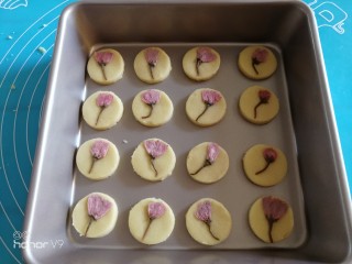 樱花曲奇饼干,用圆形模具按压，然后放入烤盘里面，轻轻的将樱花按压到面团上面。