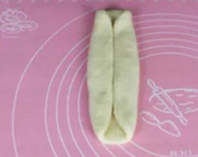 奶香土司面包#面团的发酵之旅#,拿出一个面团，擀成长方形。如图两边折进去