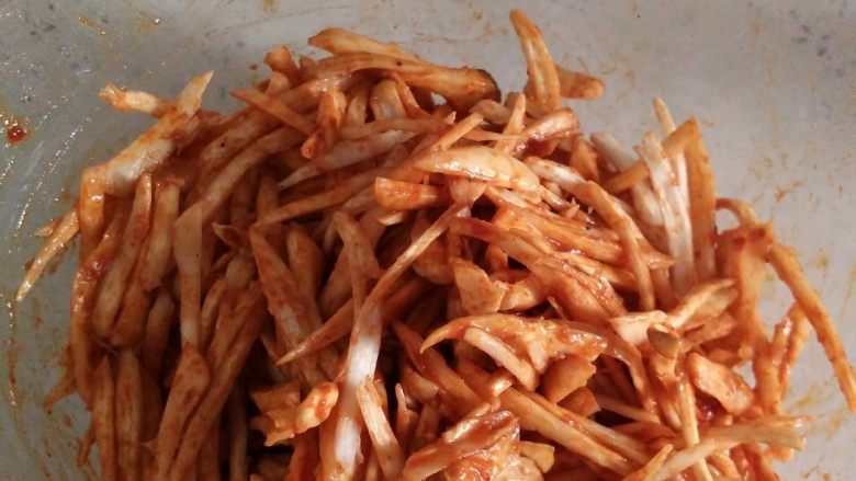 低脂小零食---烤杏鲍菇干,用手或者筷子混合均匀，使得每条杏鲍菇丝都均匀裹满酱料。