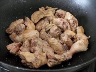 大盘鸡,4.上干锅，中火炒干鸡块的水分，炒出油，然后盛出，洗去污沬备用。