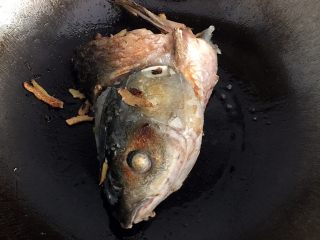鱼头豆腐汤,锅里倒入油，放入鱼头，煎至微黄