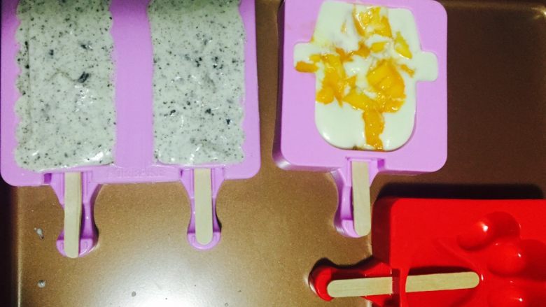 奶香十足的冰棒,剩下的冰淇淋糊倒入一点到雪人模具中   倒一半满  加入芒果果粒  再倒入冰淇淋糊
