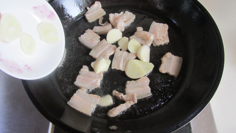 扁豆焖面,煸炒至五花肉微微出油时加入蒜片；