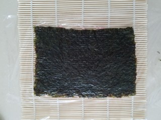 樱花寿司,压好后保鲜膜就粘在米饭上了，然后翻转过来，保鲜膜在下成，海苔在上面。