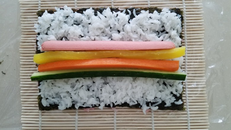 樱花寿司,铺一层拌好寿司醋的白米饭，上面放上切好的食材。