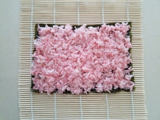 樱花寿司,把拌入樱花粉的米饭均匀的平铺在上面