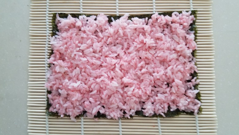 樱花寿司,把拌入樱花粉的米饭均匀的平铺在上面