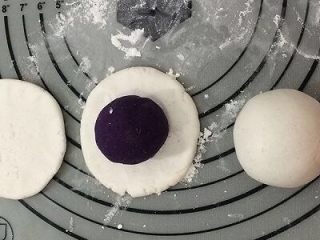 紫薯糯米饼,拿一个面团，用手捏成中间厚四周薄的饼，然后将紫薯放入饼中间，用手一点点的将紫薯包入，不要将紫薯露出