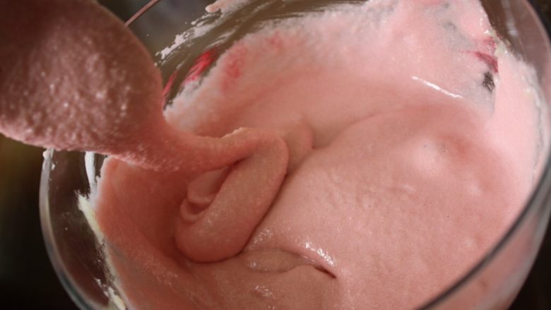 惊喜玫瑰马卡龙,把这个加入到杏仁粉了，也顺面加色剂，用勺子或筷子慢慢的搅拌均匀，一直到滑滑的感觉，需要搅拌5分钟左右