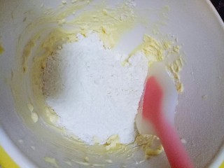 小熊抱杏仁饼干,筛入低筋面粉，用硅胶铲搅拌均匀，揉成面团。