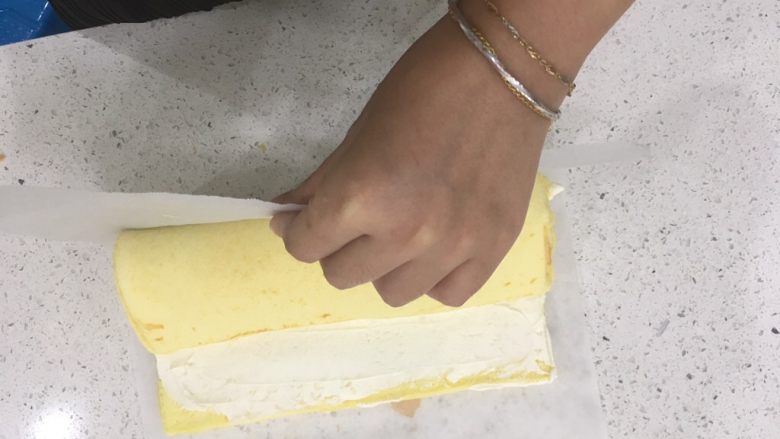 经典瑞士卷（原味）,卷好后，慢慢的拉起牛油纸，剩余的蛋糕体就会慢慢收进去了，就是让瑞士卷自己转一圈。