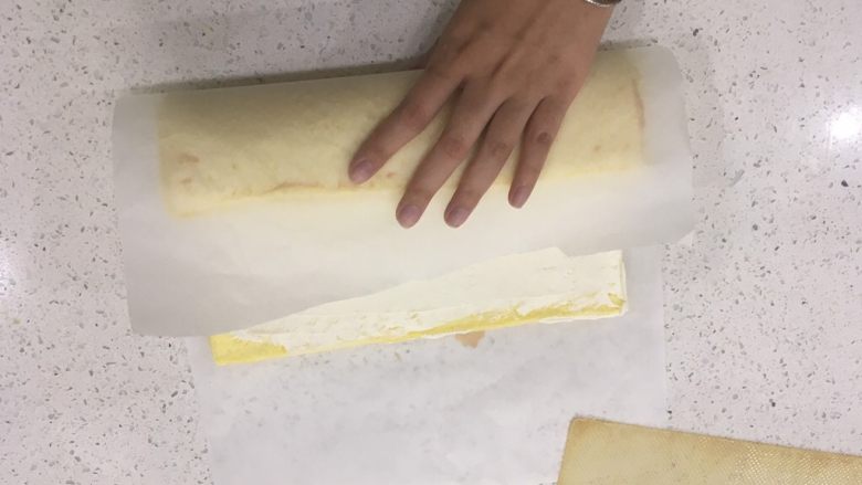 经典瑞士卷（原味）,用手拉起牛油纸，顺着奶油的厚度把蛋糕体往里卷。把蛋糕体收进去，记得动作要轻柔哦！
