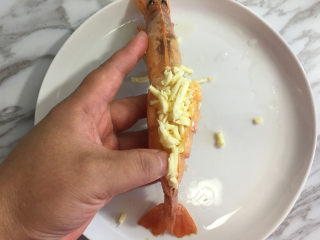 面包机版蒜蓉芝士烤大虾,然后放入芝士碎。