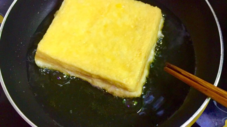 👍简单易做又好吃的港式西多士,迅速的把沾好鸡蛋液的吐司放入刚刚热好的油锅里，调中小火慢煎至金黄色