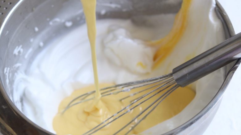 6寸淡奶油中空戚风,再把蛋黄糊倒入剩余的2/3蛋清里继续翻拌至蛋清与蛋黄完全混合均匀的转态。