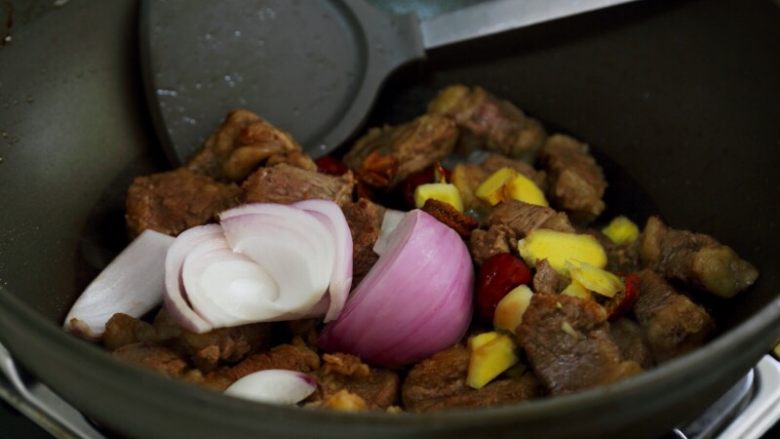 土豆烧牛肉,5.当水分差不多炒出时，将备好的调料除西红柿和小葱都放入锅中，继续保持中小火炒。