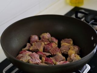 土豆烧牛肉,4.取一炒锅，不用油，用中小火将牛肉炒出水分，炒出的水用厨房纸沾去。