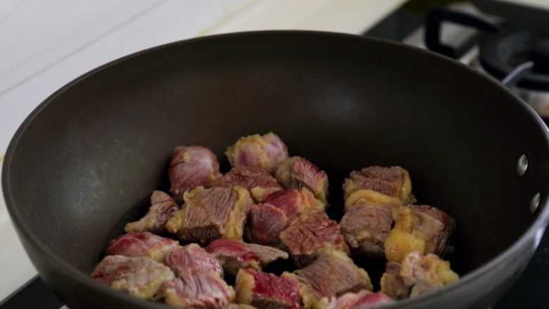 土豆烧牛肉,4.取一炒锅，不用油，用中小火将牛肉炒出水分，炒出的水用厨房纸沾去。