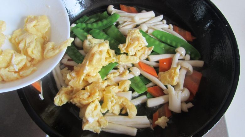 荷兰豆海鲜菇炒鸡蛋,最后放入炒好的鸡蛋进去翻炒均匀即可盛入盘中。