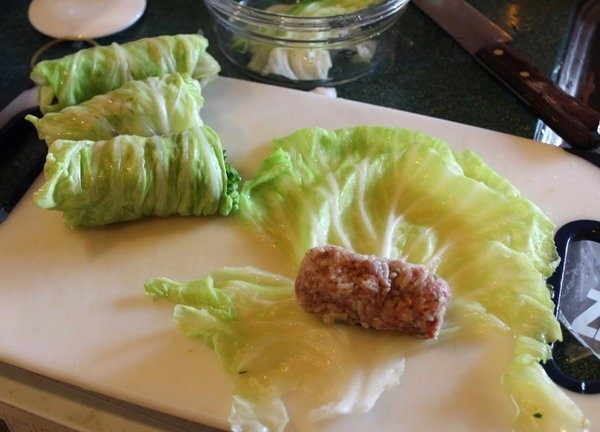 高丽菜牛肉卷,将高丽菜叶放入滚水中烫软后捞出备用。将肉团捏成适当大小的长条，用烫好的高丽菜叶卷成高丽菜卷备用。