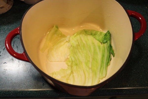 高丽菜牛肉卷,铸铁锅底部铺上剩下或较零碎的高丽菜叶。