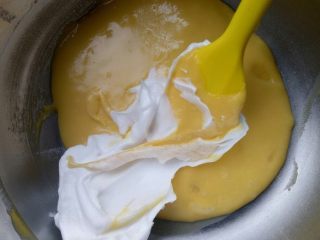 焦糖海盐可可脆蛋糕,取三分之一的蛋白霜加入蛋黄中，以划十字形方式进行搅拌均匀
