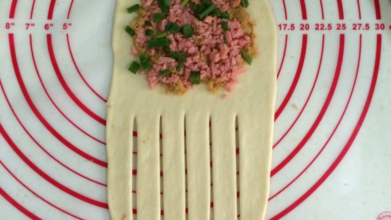 肉松香肠面包,在面片上端放在肉松、香肠粒和葱花。