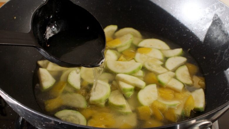 海鲜锅巴,9. 加入<a style='color:red;display:inline-block;' href='/shicai/ 845'>高汤</a>或水4-5勺。
注：这儿要用开水，或煮开的汤。如用冷汤，西葫芦和甜椒就会被煮过了。还有水不要太多，因为这是货多汤少的浓汤。