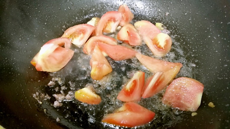 番茄炒牛肉,倒入番茄，加一点盐，翻炒一下。
