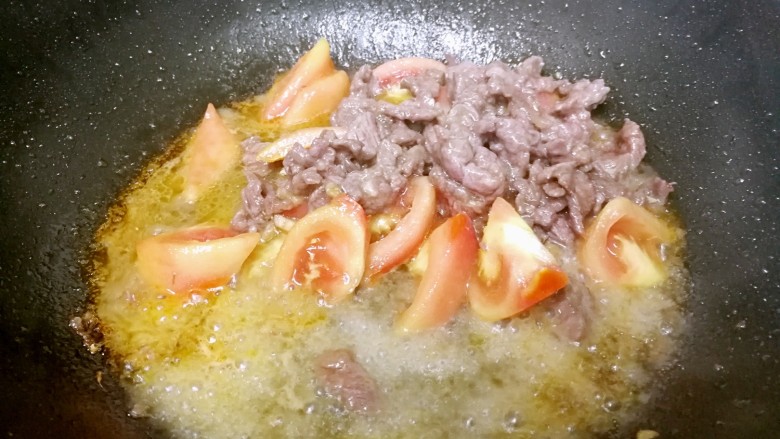 番茄炒牛肉,倒入一点热水，翻炒几下。
