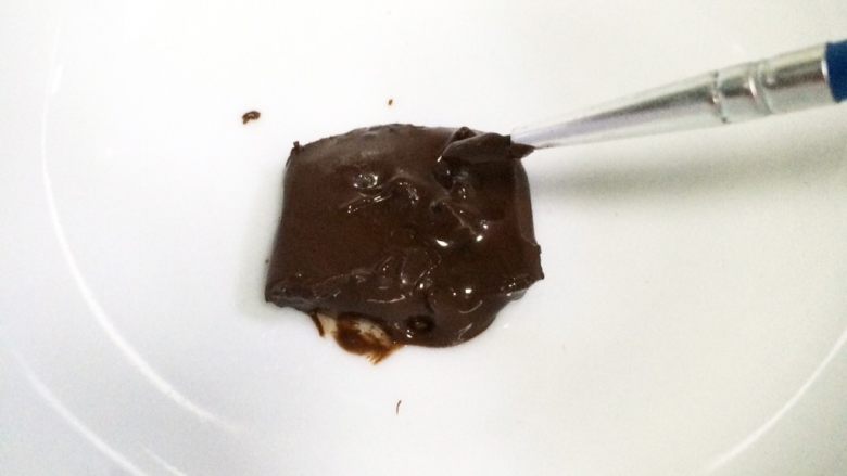hellokitty饼干,取一小块黑色巧克力放碗中，放微波炉中加热至融化，也可以隔温水至融化。