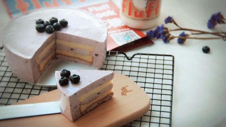 Fluff棉花糖蓝莓慕斯蛋糕,      放入冰箱冷藏4小时以上就完成了，脱模用热毛巾捂一下边缘就可以成功脱模。取出慕斯蛋糕再加点自己喜爱的蓝莓做装饰就完成了…