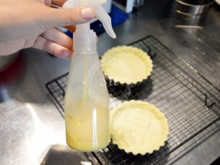 Fluff法式柠檬蛋白挞,10分钟后取出挞模，喷上蛋黄液（蛋黄液是30g蛋黄+100g牛奶打散混合均匀后过筛，冰箱冷藏大概可以保存1周）。再送入烤箱，烘烤15分钟