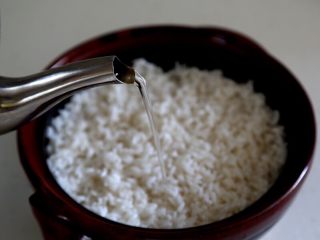 煲仔饭,5.泡好的大米入锅，倒入适量的水，要与平时烧饭水量相同，虽然大米已经泡过，但肉还会吸水。