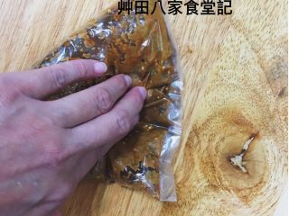 台灣府城道地小吃豆乳雞,用手將袋中的醃料混合壓勻