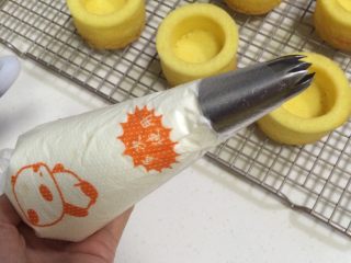 奶油水果蛋糕杯,在裱花袋随意内装入一个裱花嘴，然后再把打发好的奶油继续装入裱花袋中。