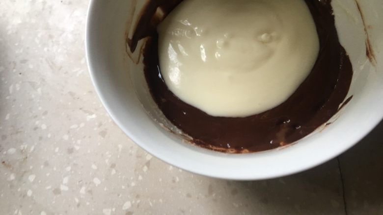 大理石冻芝士蛋糕,倒入部分奶酪糊与巧克力糊搅拌均匀。