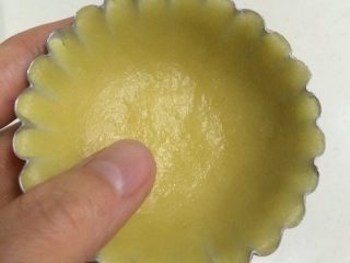 椰子挞,用双手大拇指转圈摊压成模具大小、厚薄均匀的饼皮。