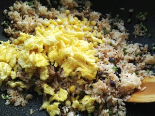 蛋炒饭,用木铲翻拌均匀，倒入玉米粒、炒好的鸭蛋。